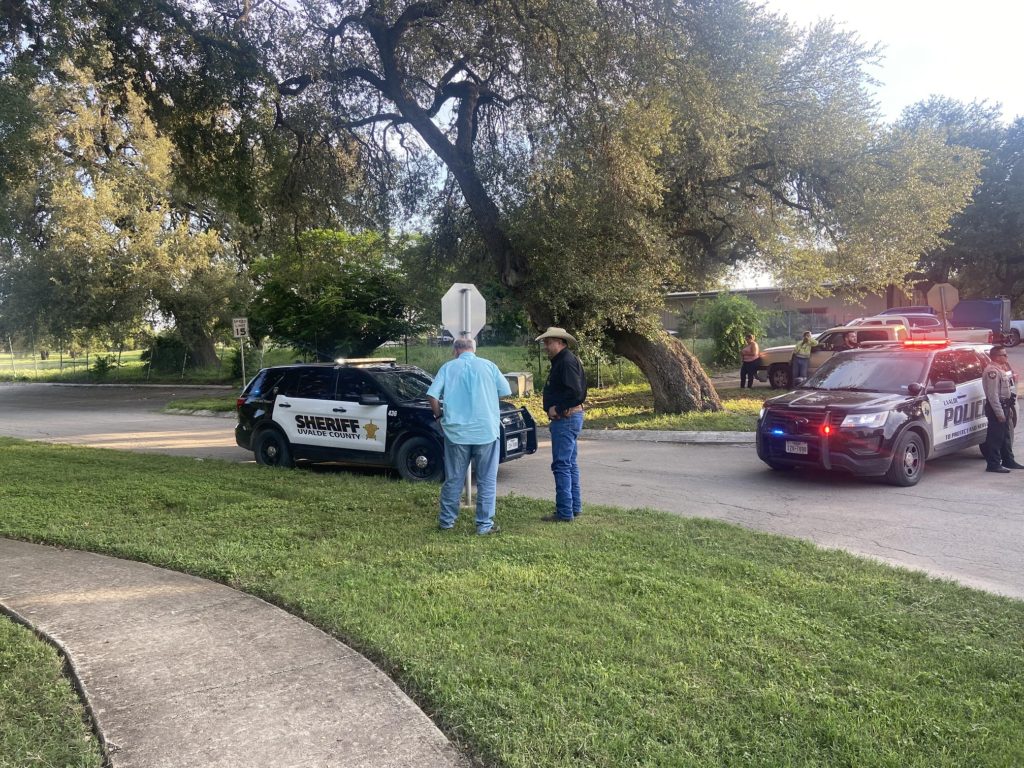 Uvalde Mayor Don McLaughlin speaks with a member of law enforcement at Memorial Park following the shooting