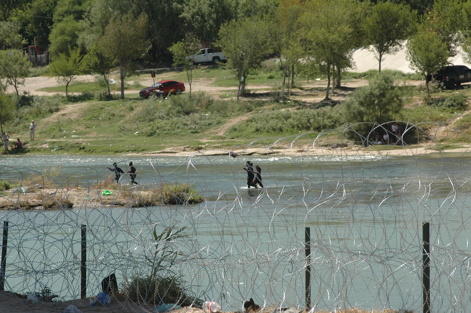 Migrants seen wading across the Rio Grande River towads the United States Border near Eagle Pass